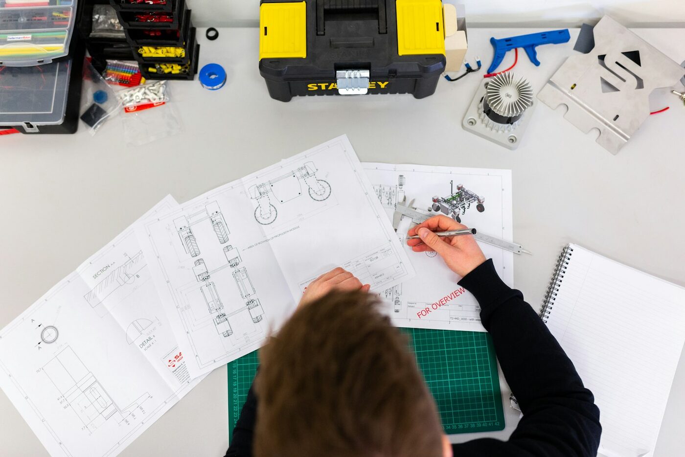 Engineer drawing technical plans at a desk