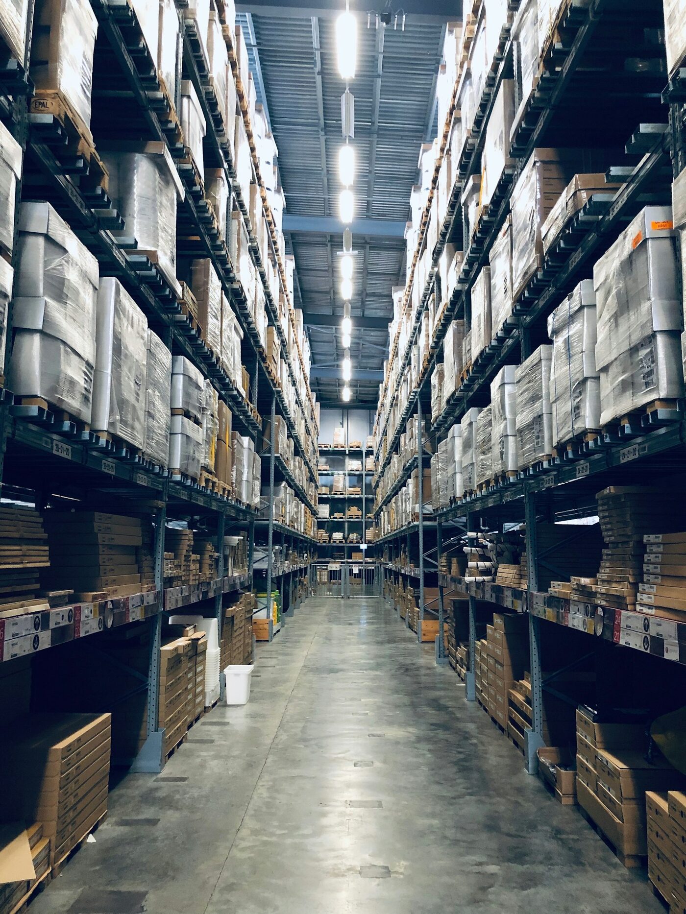 Tall warehouse racking aisle stacked with palletized goods